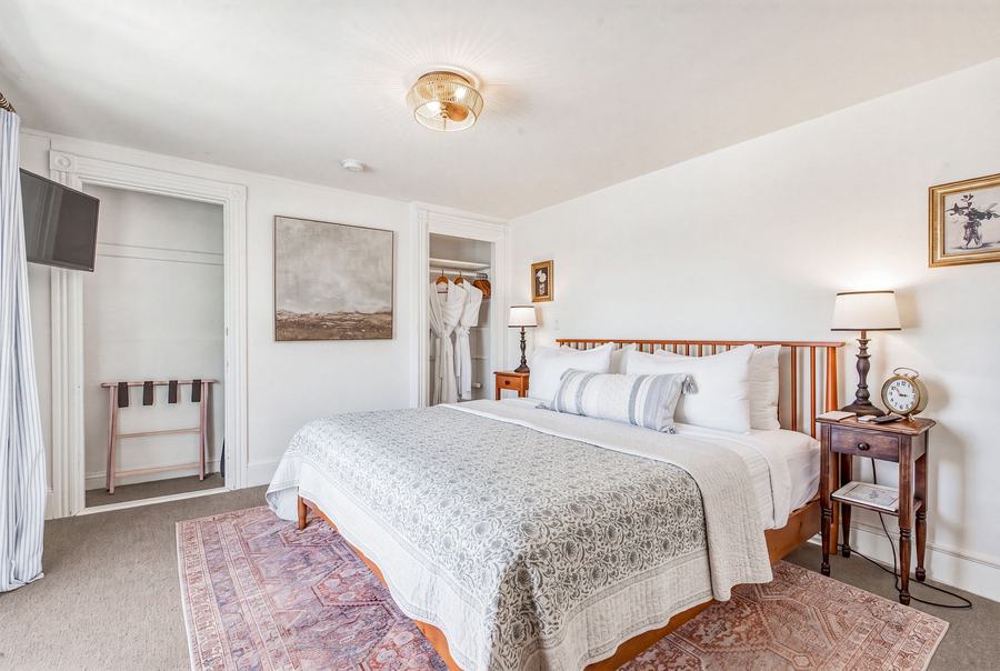 Room 11 king bedroom with coastal bedding and soft natural light