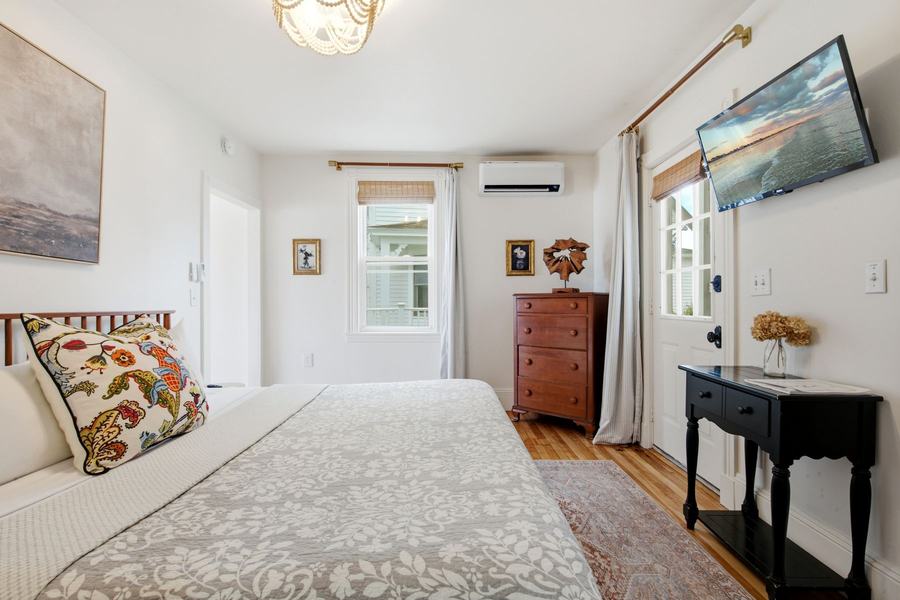 Bright king bedroom with warm wood floors and coastal furnishings