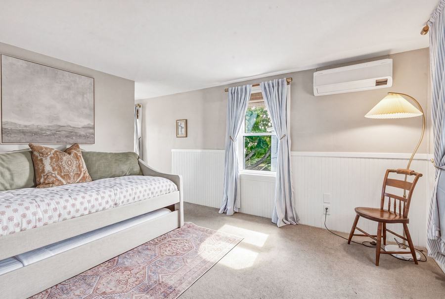 Sunlit daybed nook with coastal décor and a window overlooking the garden