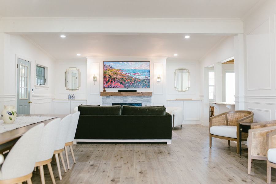 Bright shared lounge with sofa seating, fireplace, smart TV, and coastal-style decor