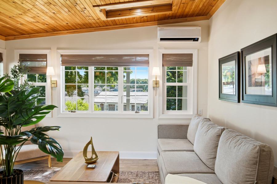 Bright sitting room with a sofa, large windows, and harbor views