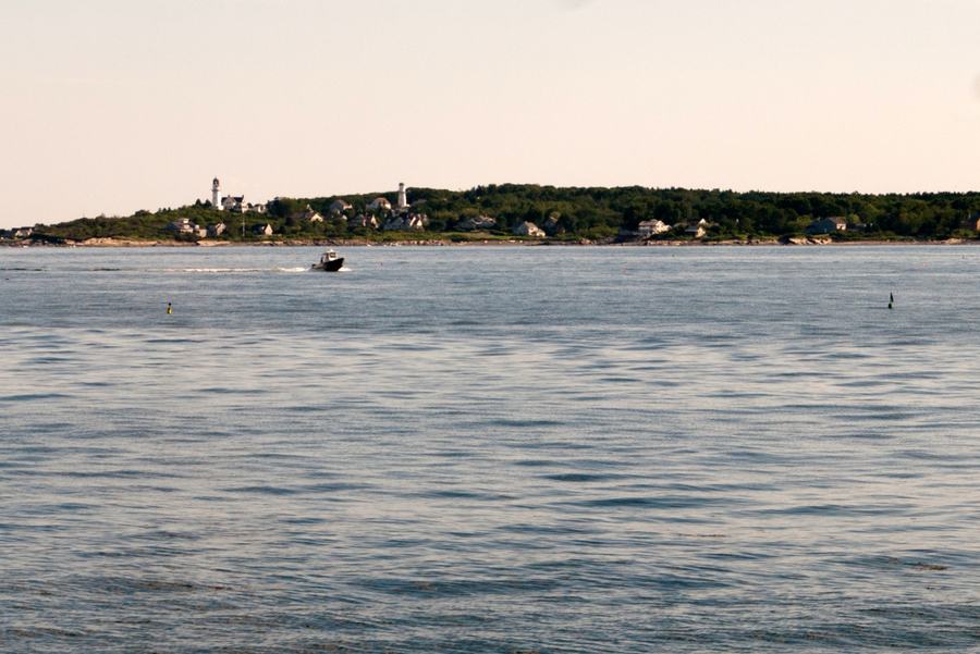 Sailboats and tour boats moored in Boothbay Harbor, Maine, on a clear summer day