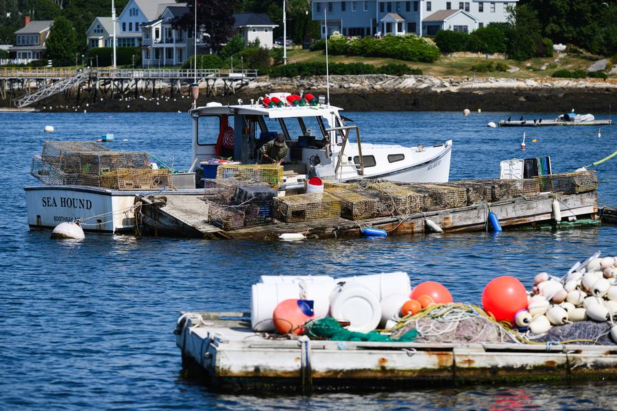 Boothbay Harbor waterfront on a clear July day with boats moored on calm water