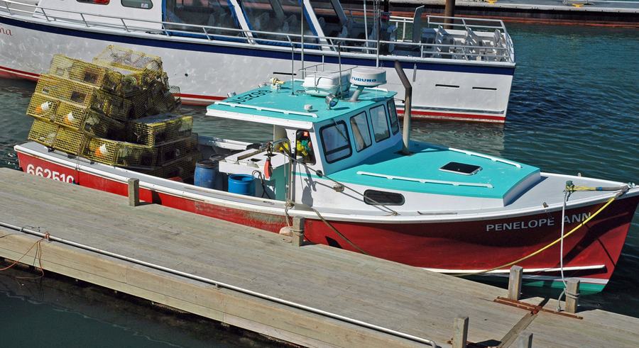 Lobster boat unloading its catch at a working wharf in Boothbay Harbor, Maine