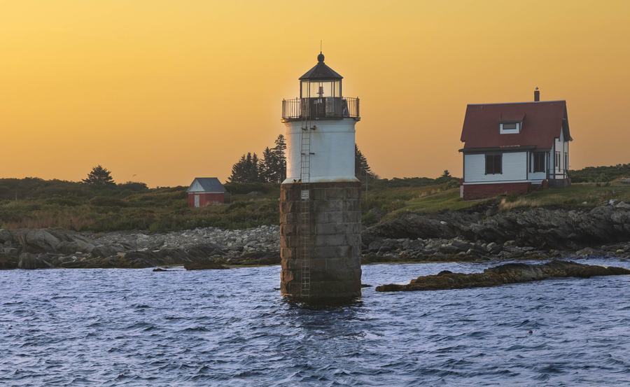 Sunrise over Boothbay Harbor with fishing boats at anchor and warm light on the water